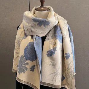 Elegant beige and blue floral cashmere-feel shawl with fringe detail on mannequin.
