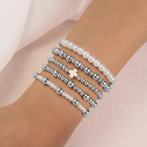 Vue rapprochée montrant les textures des perles argentées et des breloques en perles