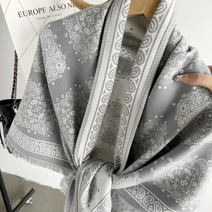 Detailed view of elegant grey paisley cashmere-like winter shawl with classic fringe edges
