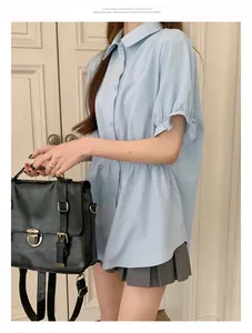 Detail view of light blue short-sleeved shirt featuring elastic waist and ruffled cuffs