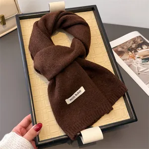 Detailansicht eines hochwertigen dunkelbraunen Wollmisch-Strickschals mit Etikett