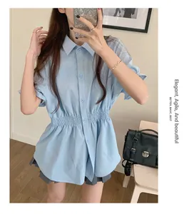 Detail of a light blue short-sleeved summer blouse with a stylish elastic cinched waist.