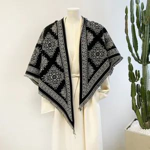 Detailed view of a black and white paisley pattern pashmina shawl with tassel fringe