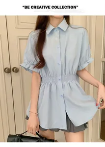 Detail of light blue short-sleeved shirt with smocked waist and ruffled cuffs