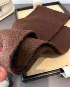 Makro-Detail eines weichen braunen Strickschals für den Winter mit hochwertiger Textur