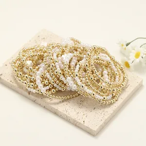 Vue détaillée de l'ensemble de 5 bracelets élastiques avec perles dorées, perles et croix
