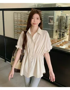 Detail showing a cream-colored short-sleeved shirt with elastic waist and ruffled cuffs.