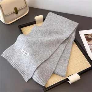 Detailansicht eines weichen grauen Strickschals aus Wollmischung mit Wintertextur