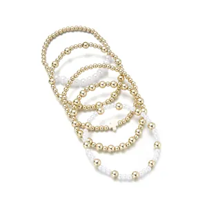 Lot de 5 bracelets élastiques en perles dorées avec perles blanches et motif croix