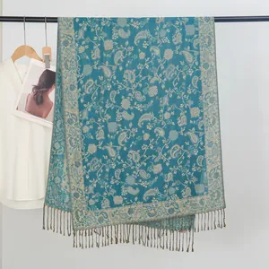 Detailansicht eines blauen Jacquard-Schals mit Paisleymuster und Fransen am Kleiderbügel
