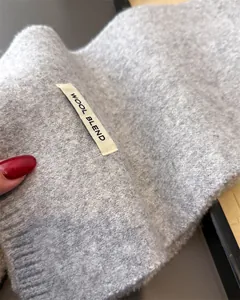 Detailansicht eines weichen grauen Wollmischschals mit Textur und Qualitätssiegel