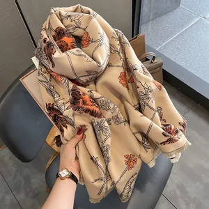 Elegant faux cashmere floral scarf with fringe edges in beige and orange.