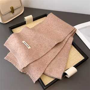 Detailaufnahme eines warmen Wollmischstrickschals in sanftem Taupe für Herbst und Winter