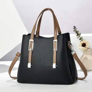 Elegante schwarze Handtasche aus strukturiertem Leder mit braunen Griffen und Schultergurt