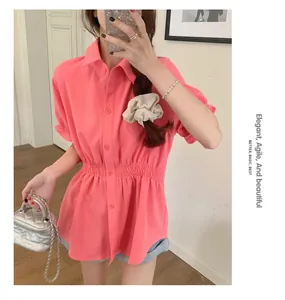Close-up of pink short-sleeved shirt featuring a flattering elastic shirred waist design