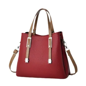Elegante rote Handtasche aus geprägtem Leder mit braunen Henkeln und Silber