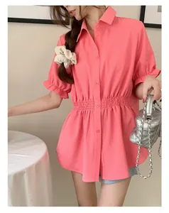 Detailed shot of a pink short-sleeved shirt featuring an elasticated waist and ruffled sleeves