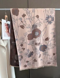 Detail view of double-sided cashmere-like shawl with elegant ink floral print and fringe.