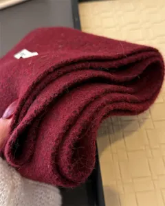 Nahaufnahme des weinroten Strickschals mit hochwertiger, weicher Wollstofftextur