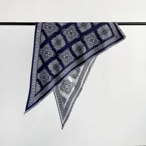 Close-up detail of navy blue paisley imitation cashmere triangular scarf with fringes