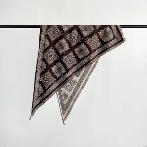 Detailed shot of brown paisley pattern on a soft faux cashmere triangular shawl scarf.