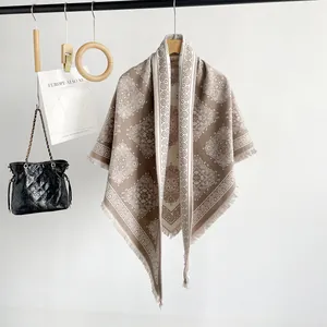Close-up of the elegant brown paisley pattern and fringe on this triangle shawl
