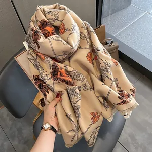 Elegant beige shawl with orange floral ink-wash print and fringed edges for winter.