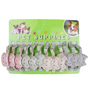 Multiple cat head shaped pet collars with cute designs displayed on a green card