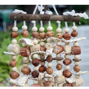 Detailweergave van groot papegaaienspeelgoed met natuurlijk hout, zaden en loofah.
