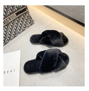 Détail de haute qualité des chaussons en fausse fourrure noire à brides croisées.