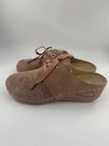 Gros plan latéral de mules compensées élégantes à bout fermé pour femmes rose poudré