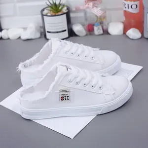 Mules de lona blanca para mujer con bordes deshilachados y un cómodo diseño sin cordones