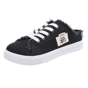 Zapatillas tipo mule de lona negra para mujer con bordes deshilachados y sin talón.