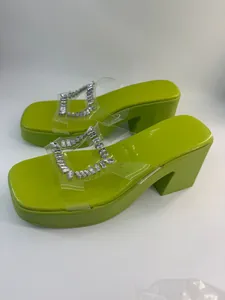 Lime green platform heeled sandals featuring sparkly rhinestone transparent PVC straps.