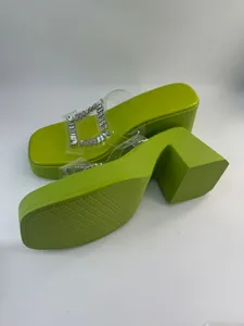 Detail of lime green platform slippers with rhinestone buckle and textured sole