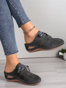 Vue détaillée de mules à talons compensés grises avec découpes et coutures décoratives