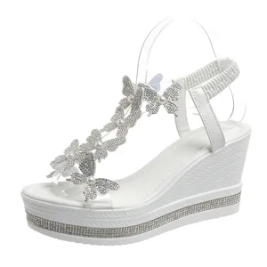 Elegant white wedge sandals featuring rhinestone butterflies and pearls decoration