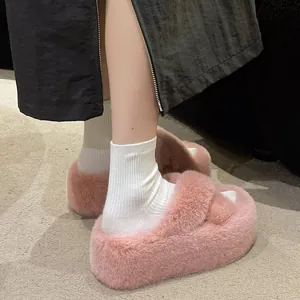 Detailansicht von rosa flauschigen Plateauslippern mit dicker Sohle und Socken.