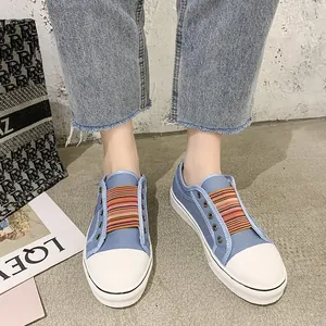 Blaue Canvas-Sneaker zum Reinschlüpfen mit bunten Gummibändern und weißer Kappe