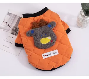 Detailed close-up of orange quilted winter pet vest with cute cartoon reindeer patch