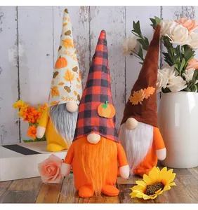 Dreiergruppe Herbst-Gnome mit Kürbis-Hüten und Ahornblatt-Dekorationen im Detail