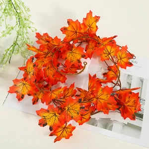 Primer plano de guirnalda de hojas de arce artificiales en tonos otoñales vivos.