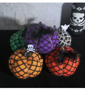 Macro view of handmade knitted Halloween pumpkins with festive skull decorations