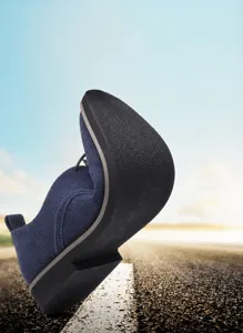 Detailed view of the highly flexible rubber sole on blue suede men's casual dress shoes
