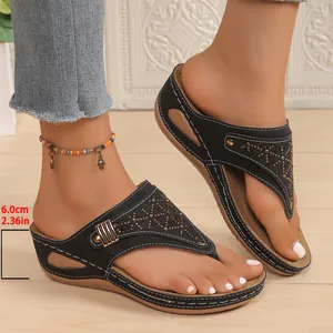 Dettaglio di sandali neri con zeppa da donna con tacco da 6 cm e strass decorativi