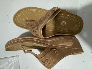 Vista di sandali con zeppa marroni con cinturini traforati al laser e suola alta