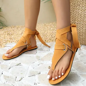 Detailaufnahme gelber Zehensteg-Römersandalen mit modischen Schnallenriemen am Knöchel.