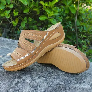 Vista detallada de sandalias de cuña para mujer con bordados florales en correas marrones