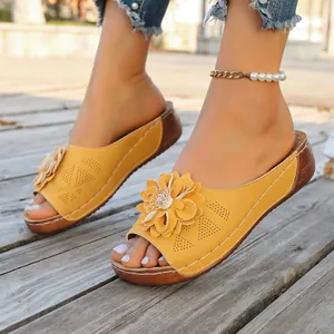 Close-up detail of yellow women's wedge slippers with stylish decorative floral accent.