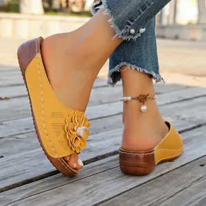 Detailed macro shot of yellow women's wedge sandals featuring a large decorative flower
